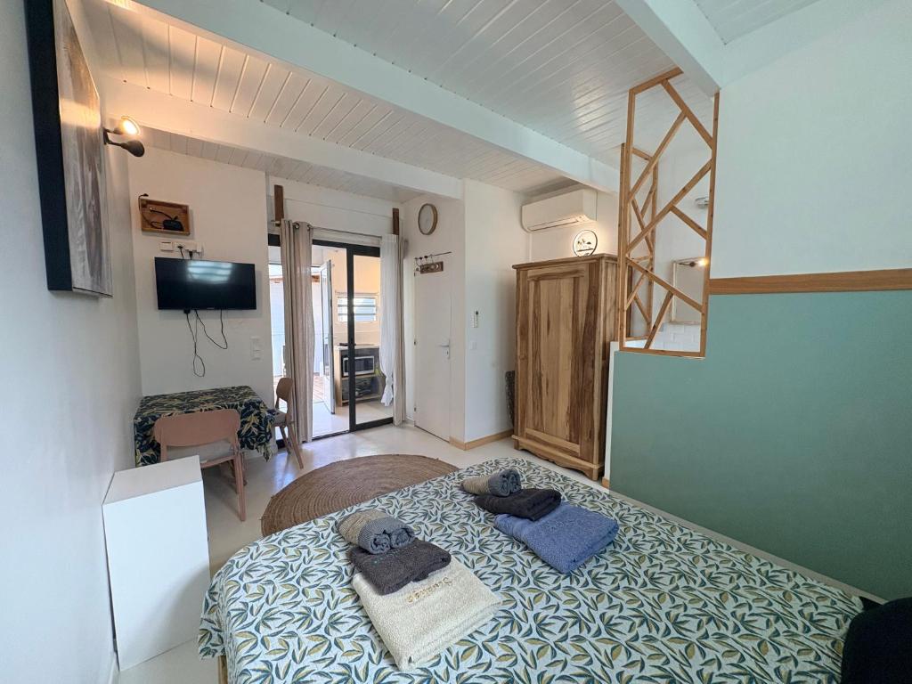 um quarto com uma cama com toalhas em Studio sucrier 150m des plages orient bay em Orient Bay