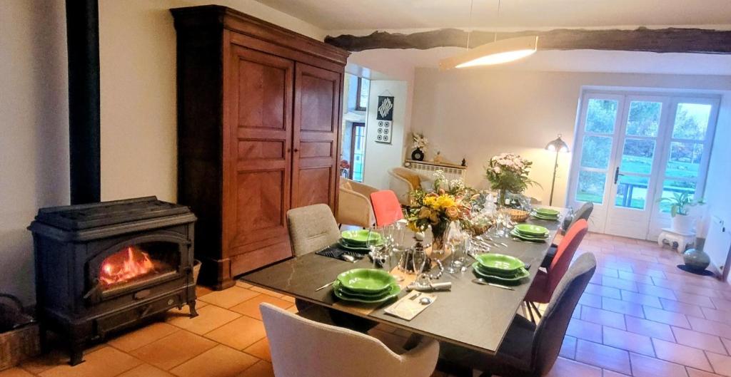 a dining room with a table and a fireplace at La Colline Gersoise-Piscine-Sauna in La Sauvetat