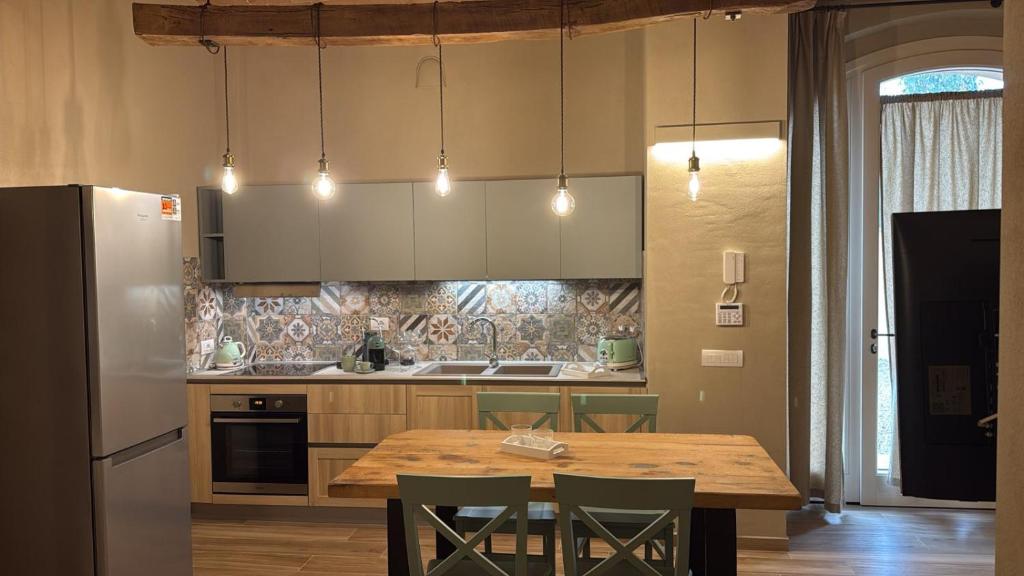 a kitchen with a wooden table and a refrigerator at Podere Gorette in Poggibonsi
