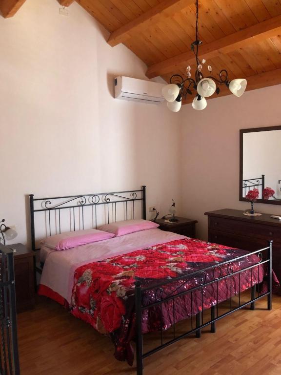 a bedroom with a bed with a red bedspread at Casa relax Nasiu in Perdaxius