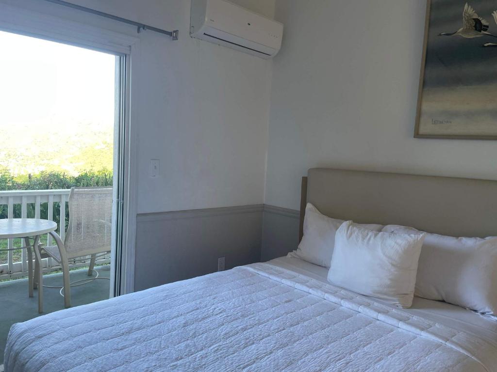 een slaapkamer met een bed en een balkon met een tafel bij Queen Deluxe Double at Boundless Bliss Hotel in Raphune