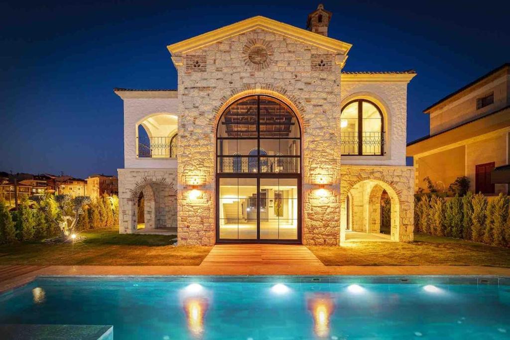 ein Haus mit einem Swimmingpool davor in der Unterkunft Spectacular sea views Villa with pool in Eskiömerler