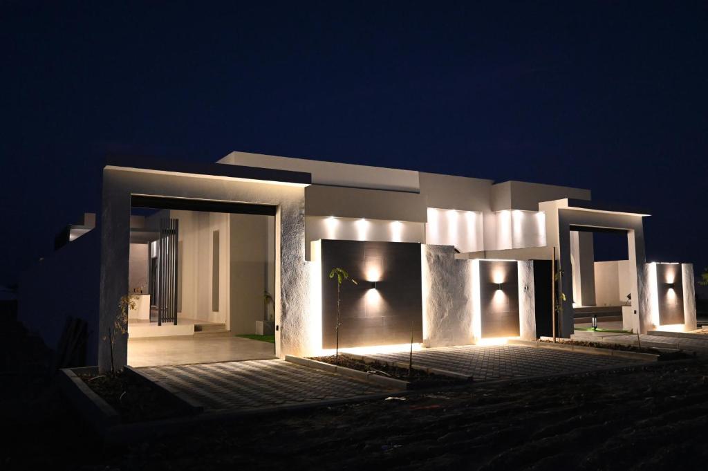 una casa iluminada por la noche con luces en Nasma chalet, en Barka