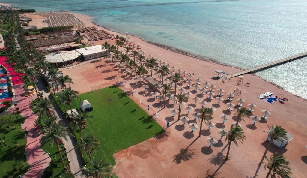 an aerial view of a beach with palm trees and the ocean at Family Holiday 2 Bedroom Chalet with free Beach & Pool in Sharm, Egypt in Sharm El Sheikh