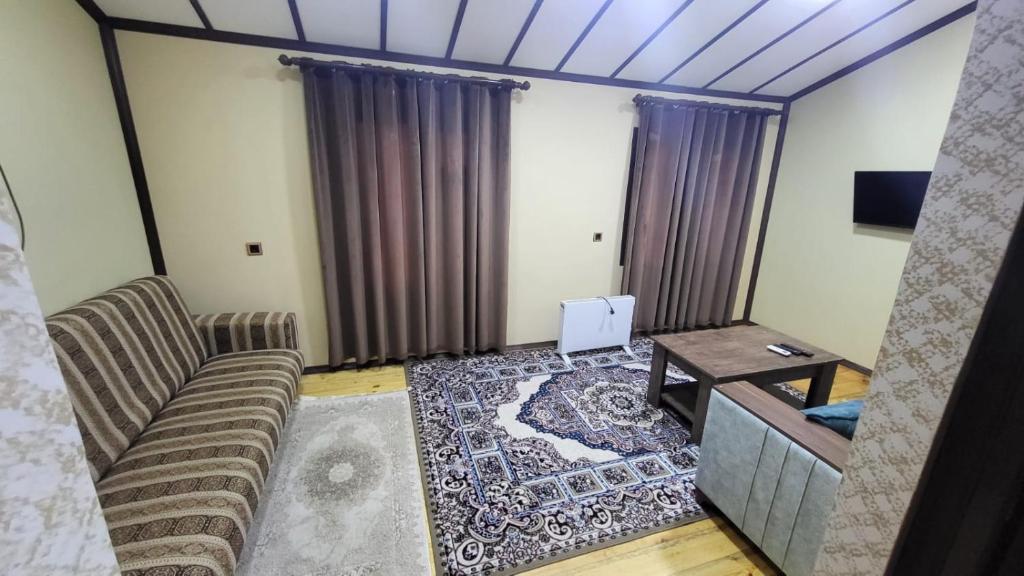 un soggiorno con un divano e un tavolo di Hotel Yaşıl Park a Mekhrably