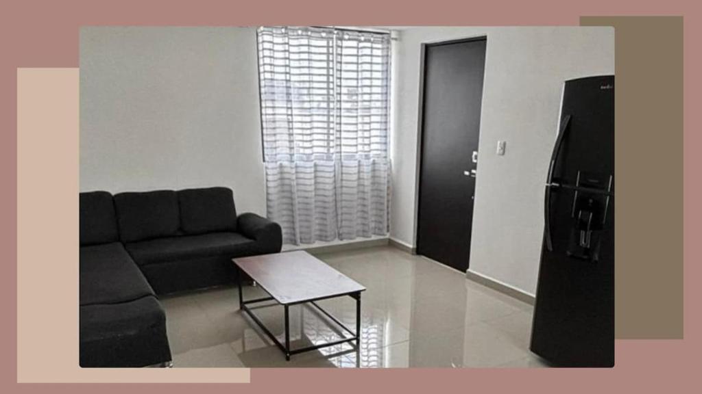a living room with a black couch and a table at Estancia del Volcán in Santa María Coronanco