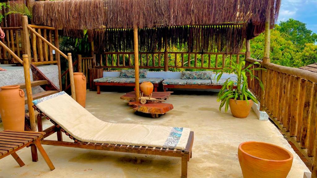 a patio with swings and chairs and aiki at Eliza, Bangalô vista mar em Trancoso in Trancoso