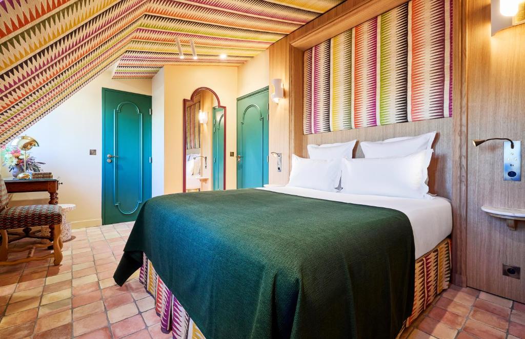 a bedroom with a large bed with green doors at Hôtel Prince de Conti - Hôtel Rénové in Paris