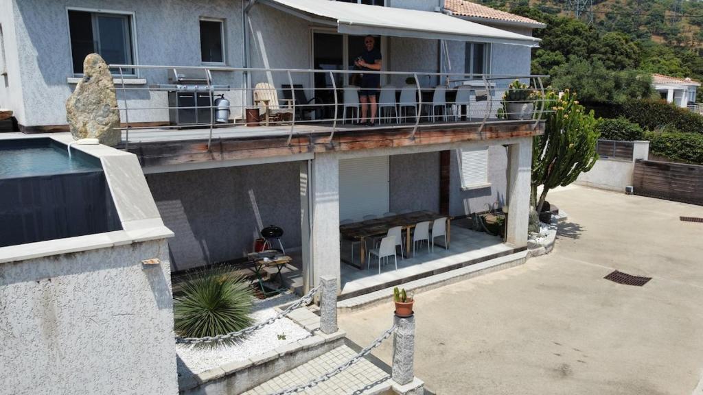 a woman standing on the balcony of a house at Paradiso Apartment 4 people in Furiani