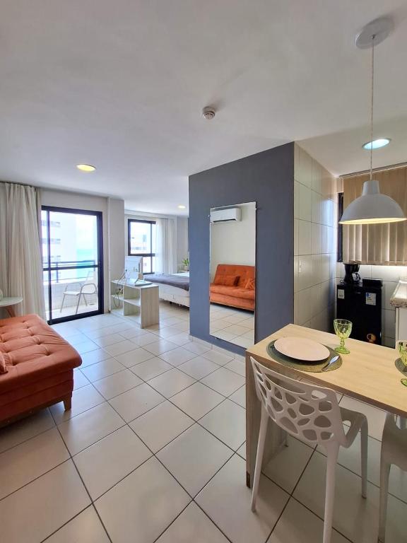 a living room with a couch and a dining room at Flats Vista Mar PontaNegra in Natal