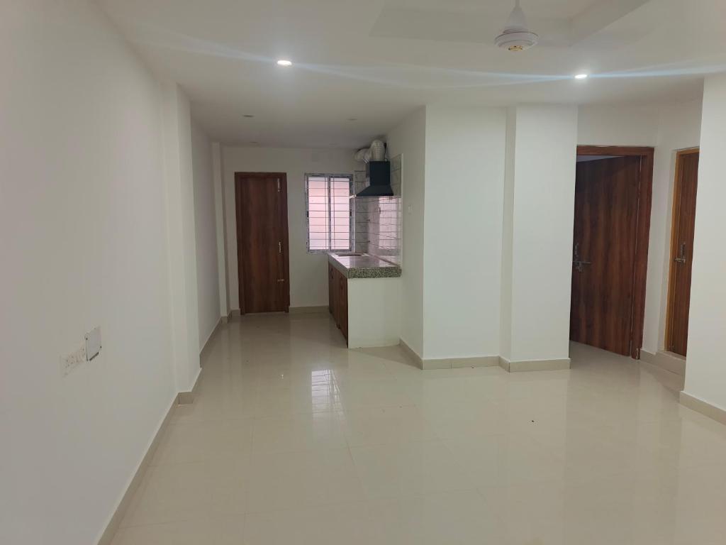 an empty living room with white walls and white floors at Purabi homestay in Silchar
