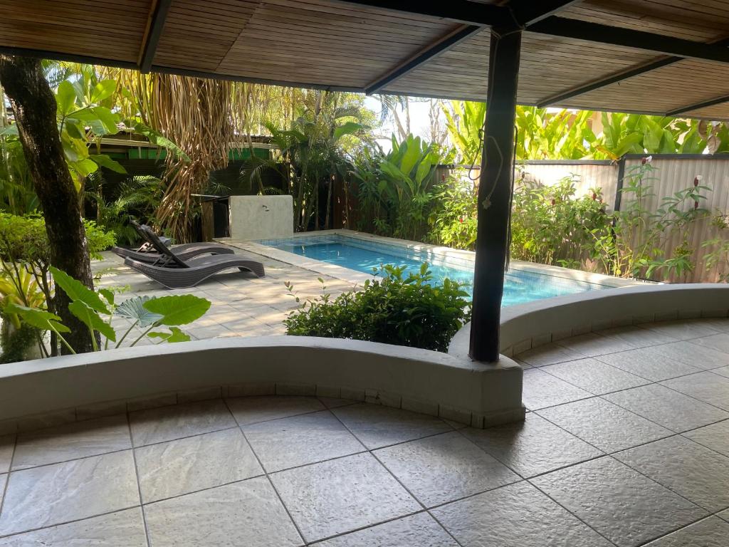 a swimming pool in a garden with a pergola at Beach Villa S in Santa Teresa Beach