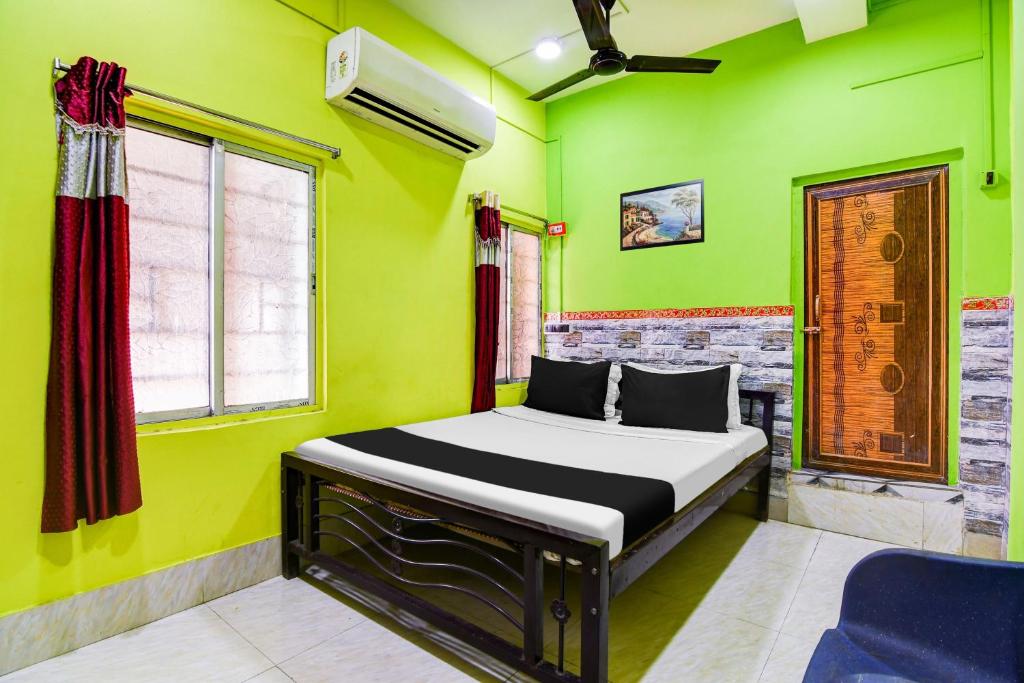a bedroom with a bed in a green room at Hotel O Raja Lodge in Kolkata