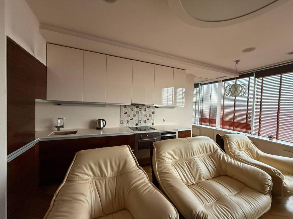 een woonkamer met 2 stoelen en een keuken bij Мост сити АПП 138 ЛЮКС in Dnipro