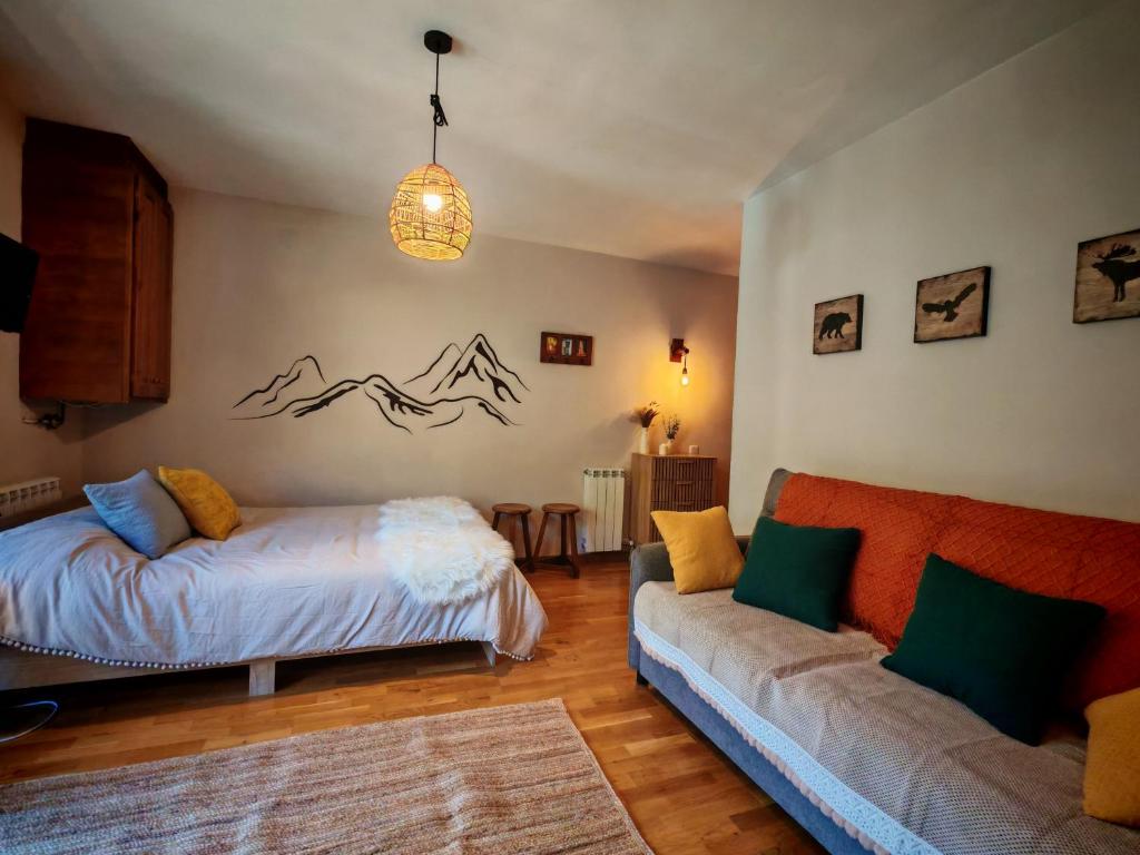 a living room with a bed and a couch at Tu rincón rústico con balcón y vistas - Erta 2 in Pla de l'Ermita