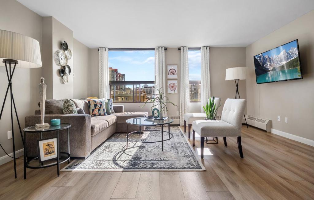 a living room with a couch and a table at Contemporary, cozy & easy to Rocky Mountains from Calgary ! in Calgary