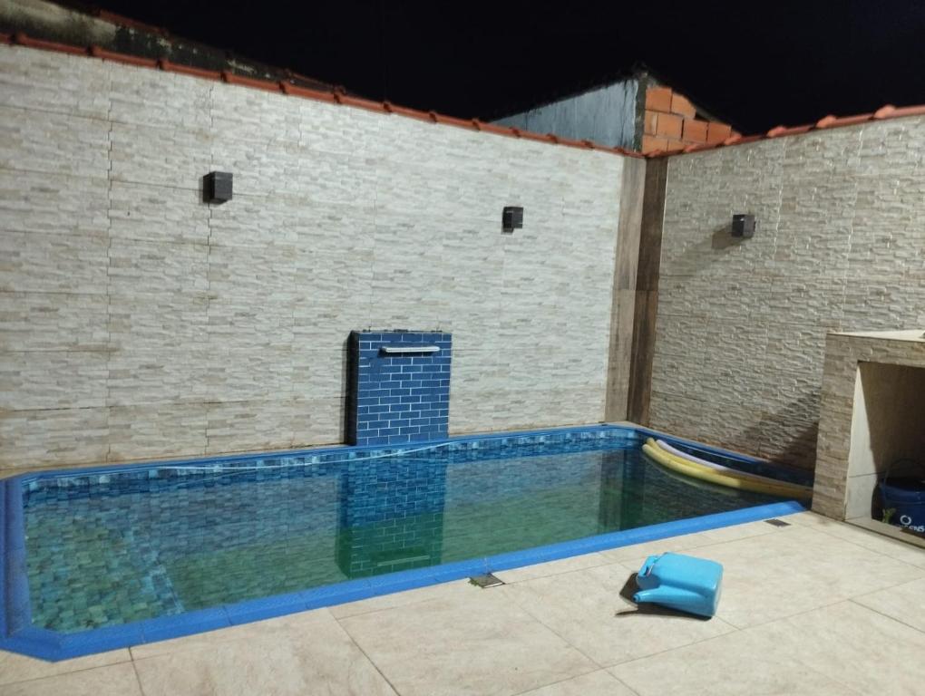 une piscine avec une gondole dans un mur de briques dans l'établissement Residence Lisboa, à Itanhaém