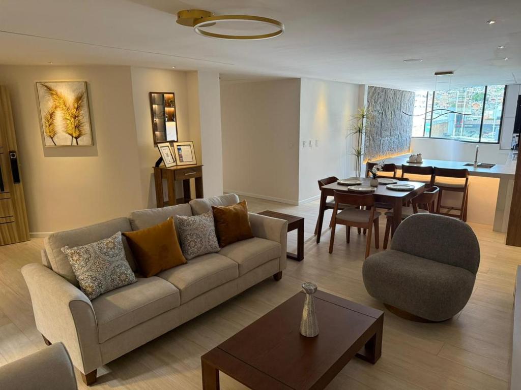 クエンカにあるDepartamentos SKYHOMEのソファのあるリビングルームとダイニングルーム