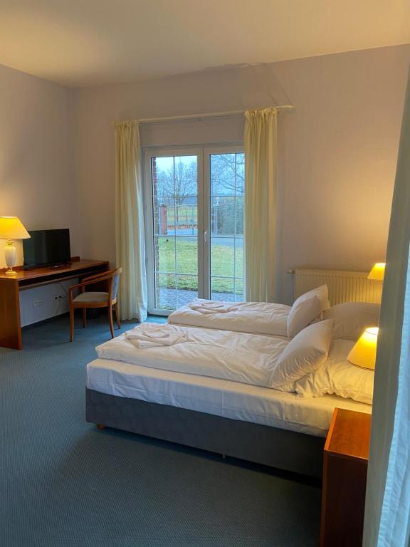 een slaapkamer met een bed, een bureau en een raam bij Schüler & Simon GbR "Kleine Landvilla" in Meuro