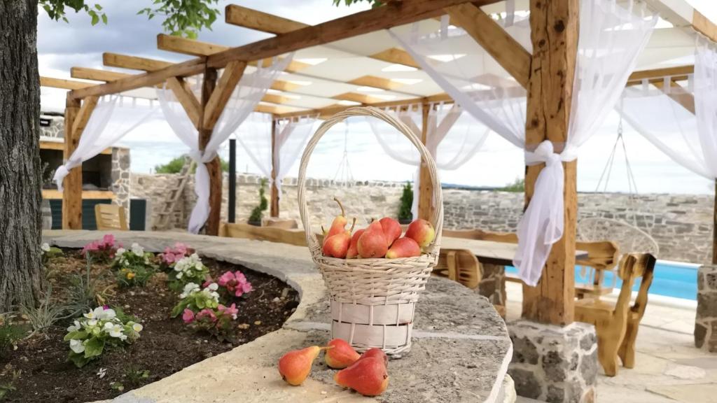 een fruitmand op een tafel bij Juniper Stone Cottage by Villas Guide in Alavanja