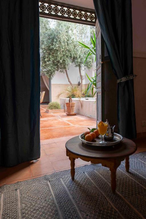 - une table avec une assiette de fruits dans une pièce dans l'établissement Riad le Jardin de Mina, à Marrakech