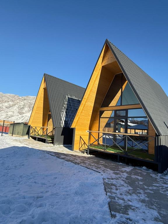 Alban في Saty: مبنى كبير ذو سقف مائل في الثلج