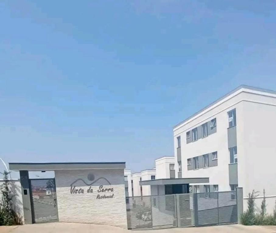 un grande edificio bianco con un cartello davanti di Apartamento Moderno e Confortável a Lavras