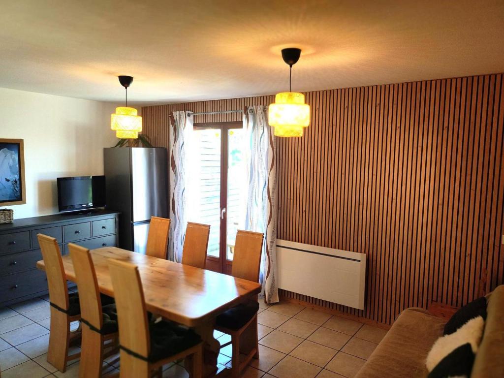 een keuken met een houten tafel en een eetkamer bij Chalet Mitoyen 7p avec Piscine, Sauna, Parking Gratuit et Proche Commerces - FR-1-863-8 in Le Dévoluy