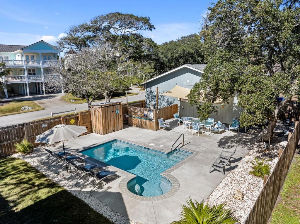 een achtertuin met een zwembad en een hek bij 4bdrm OKI Gem - Steps to Beach with Poolside Oasis in Yaupon Beach