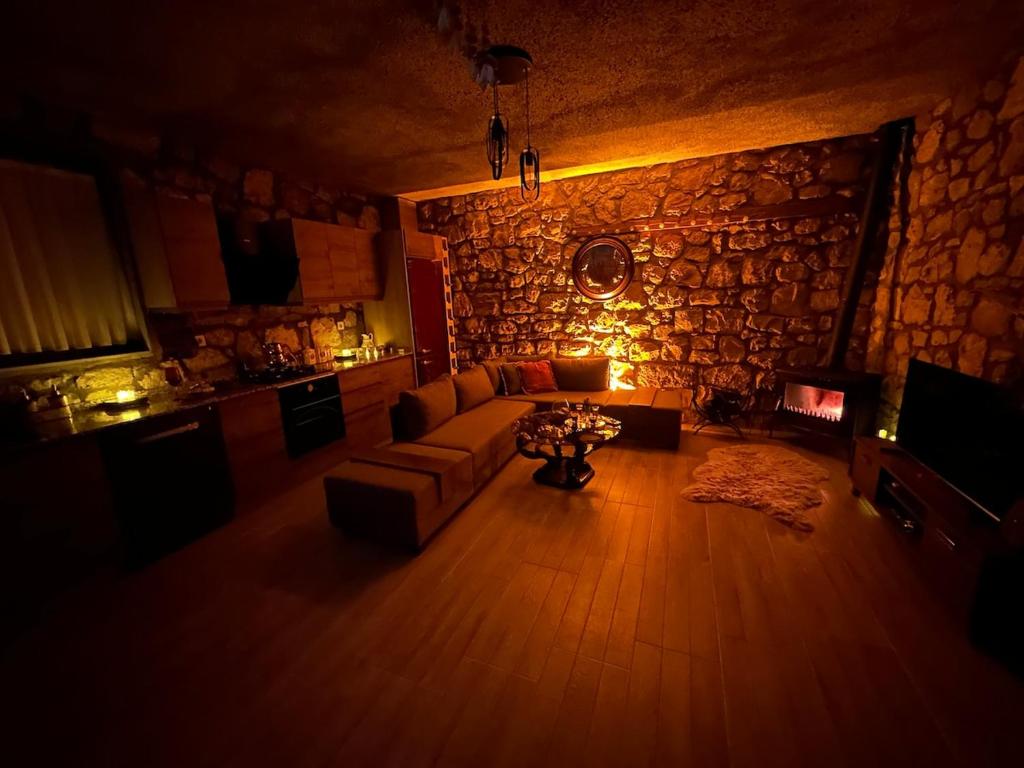 een woonkamer met een bank en een stenen muur bij Kösedere Stone Houses in Karaburun