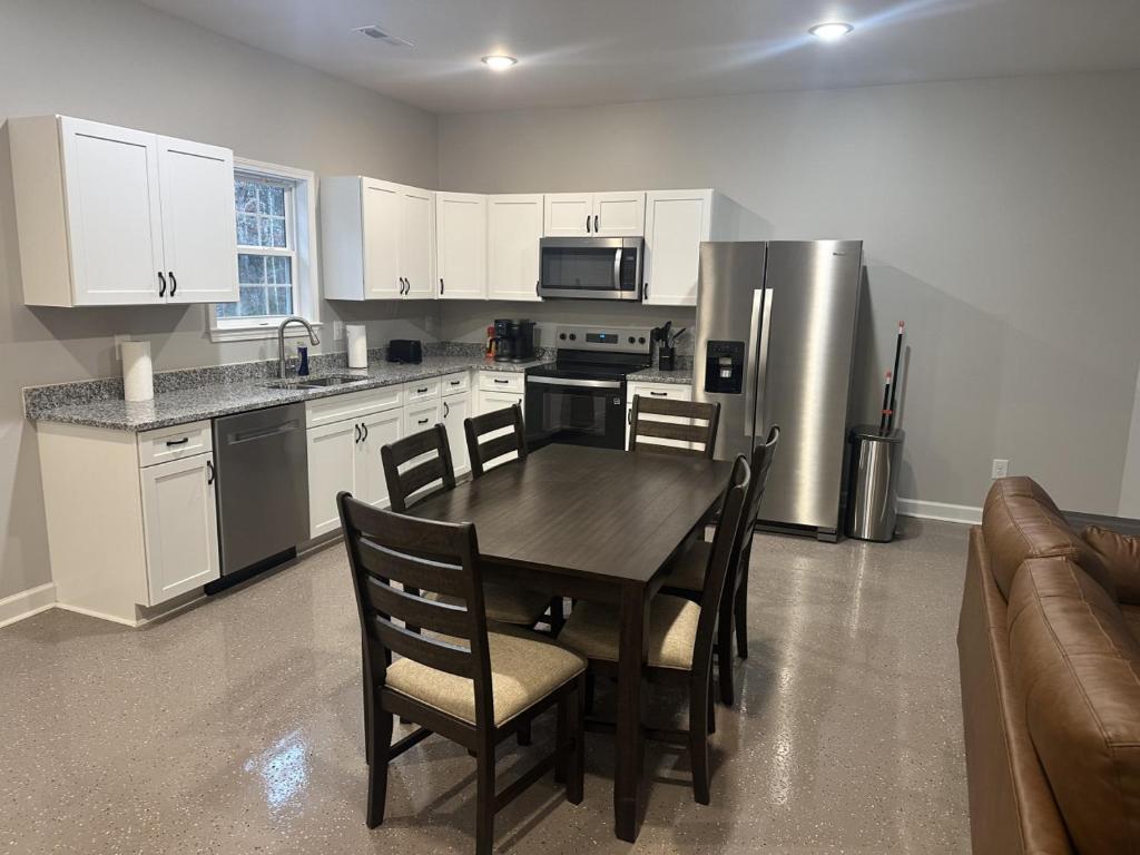 a kitchen with a table and a stainless steel refrigerator at The Buford T Justice Suite in Lexington