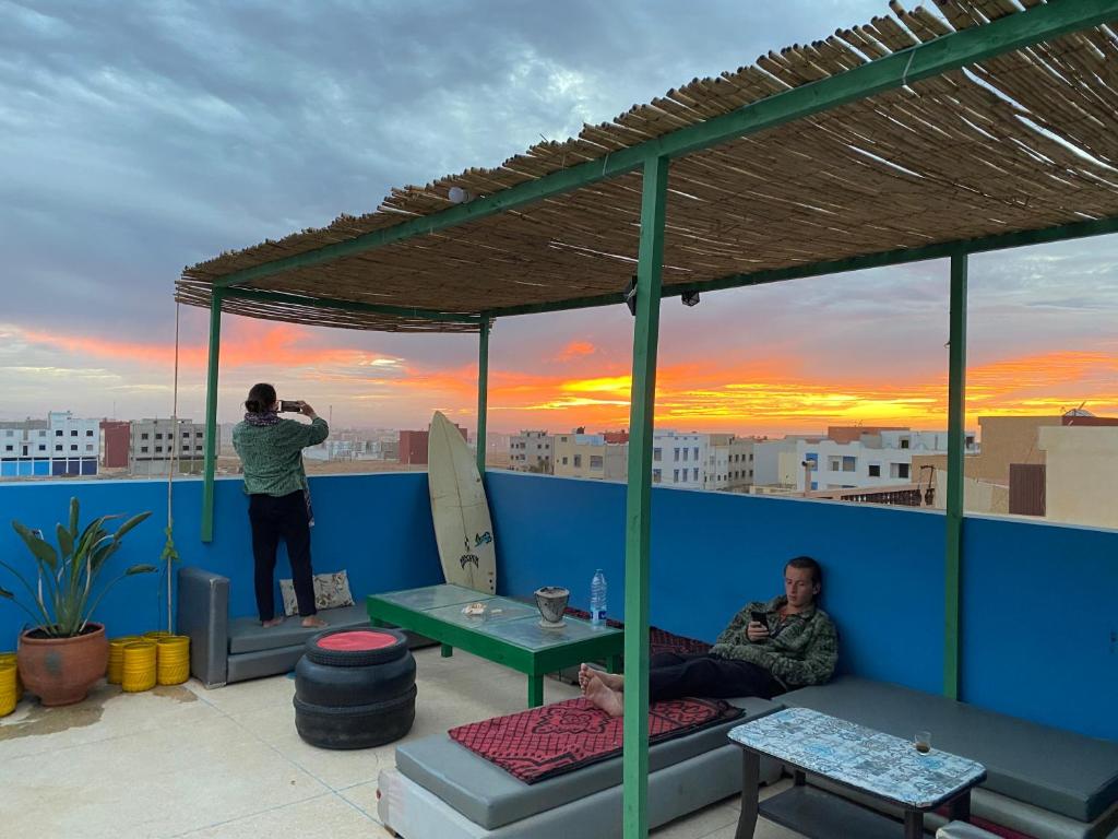 a man taking a picture of a man on a roof at Mirleft Hostel in Mirleft