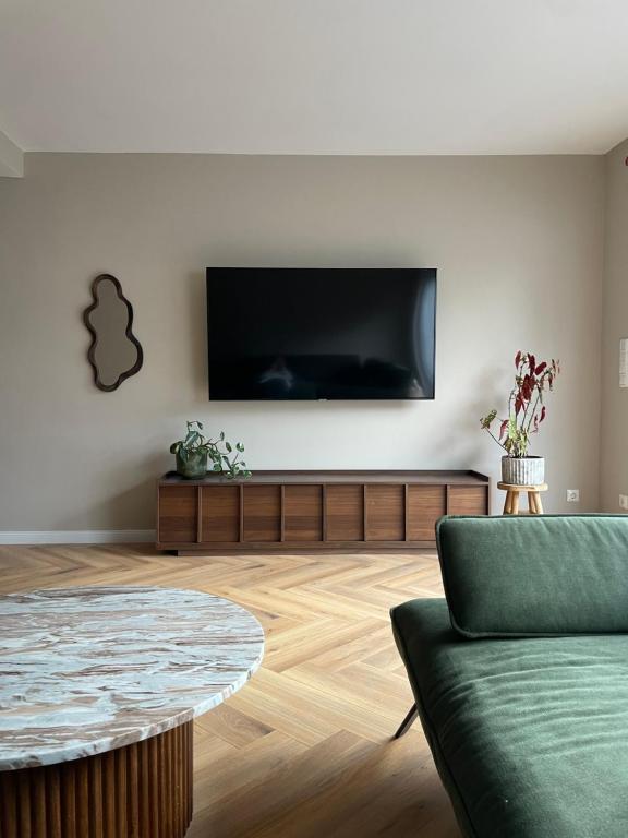 Modernes Haus mit Garten in Windberg, ruhig & zentral في مونشنغلادباخ: غرفة معيشة مع تلفزيون بشاشة مسطحة على الحائط