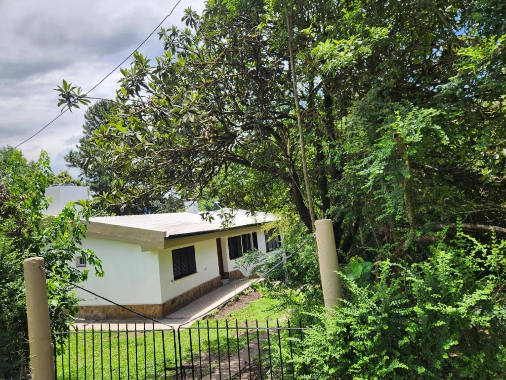 a small white house behind a fence at Davolio Hosting in Yerba Buena