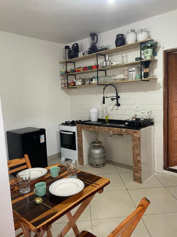 a kitchen with a table with plates on it at KitNet em Caraíva-Nova Caraíva in Caraíva