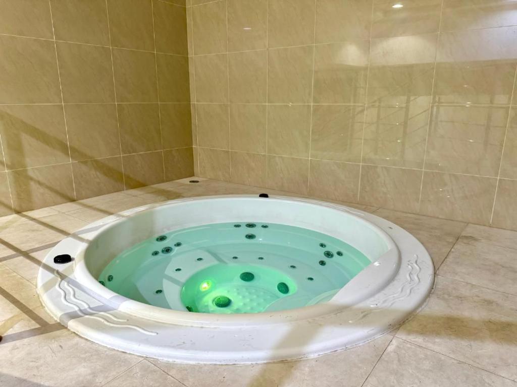 una vasca da bagno con liquido verde di Ajman Corniche Residence ad Ajman