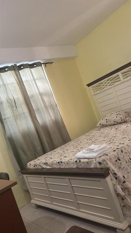a bedroom with a bed with a metal headboard at J's vacation home in Wallhouse
