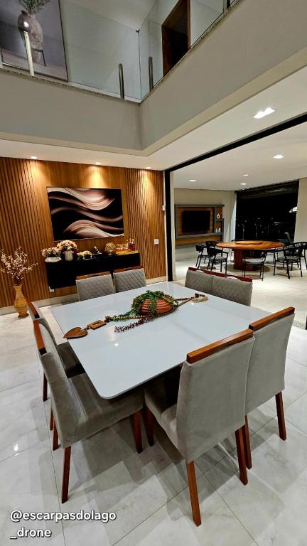 a dining room with a white table and chairs at Casa Amaral in Capitólio