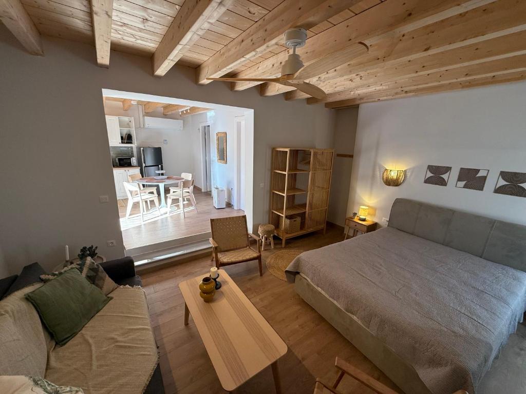 a bedroom with a bed and a living room with a table at Kantouni Corfu in Potamós