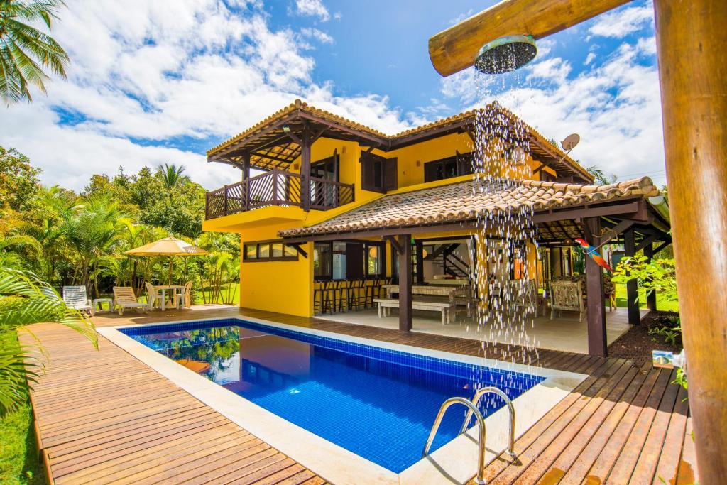 a villa with a swimming pool and a house at Casa Edy in Praia do Forte