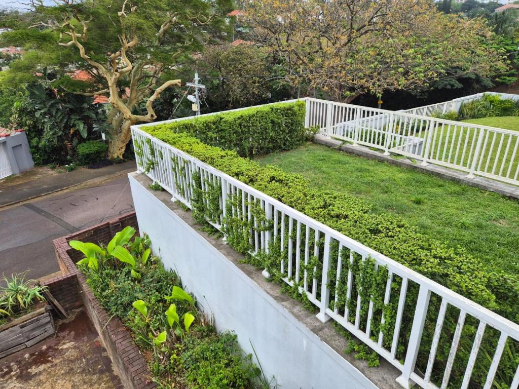 a white fence in a garden with green plants at Holland Manor in Durban
