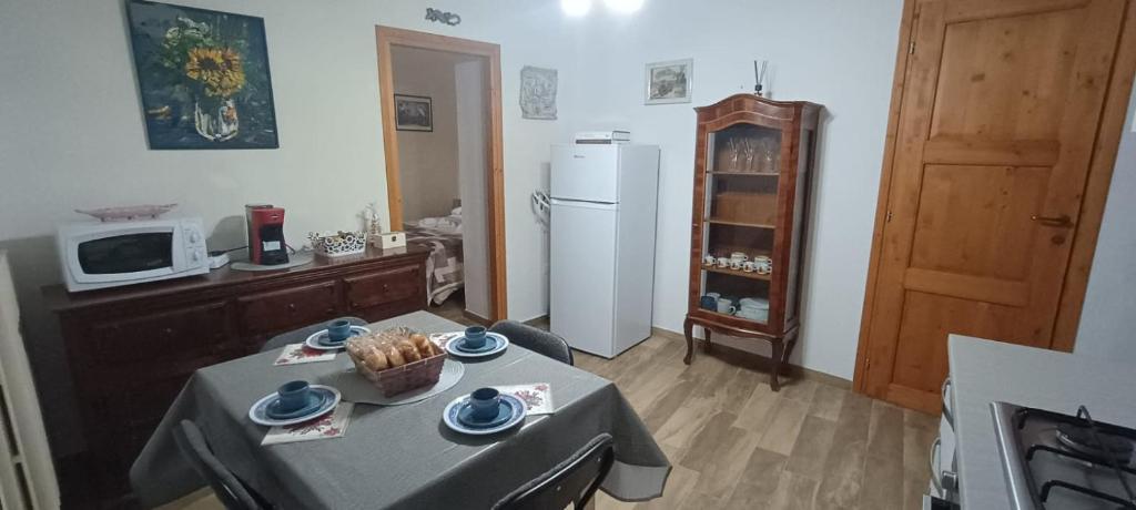 オルヴィエートにあるLa Dolce Orvietoのテーブルと冷蔵庫のあるリビングルーム