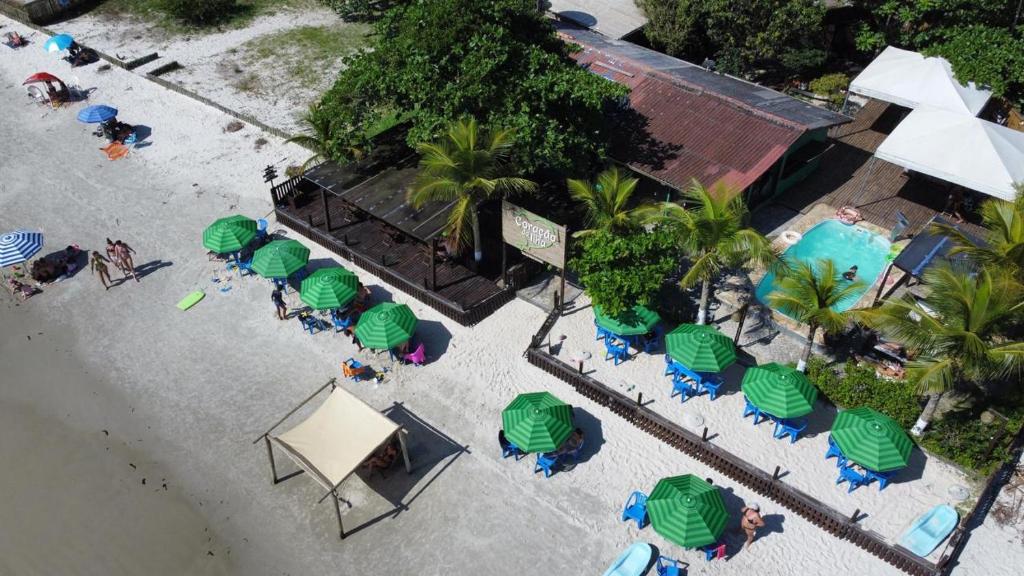 Pousada Coração da Ilha do Mel في إيلها دو ميل: منظر علوي للشاطئ مع الكراسي والمظلات