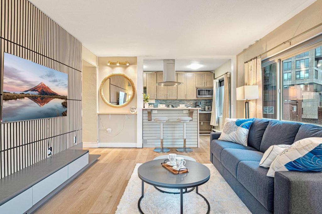 un soggiorno con un divano blu e un tavolo di Downtown Seattle Corner Unit with Skyline Views a Seattle