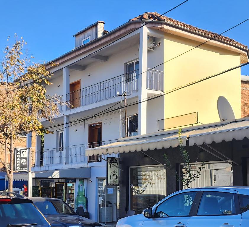 ein weißes Gebäude mit davor geparkten Autos in der Unterkunft Villa Star in Tirana