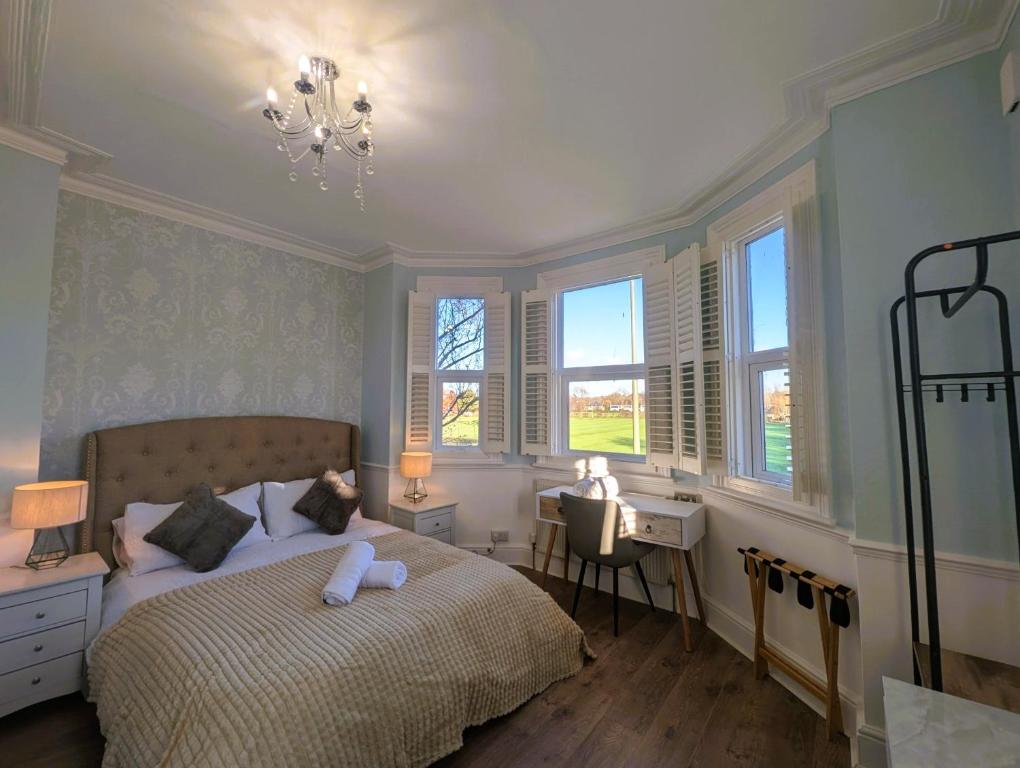 una camera da letto con un letto, una scrivania e finestre di Lakeside Oxford Hotel a Oxford