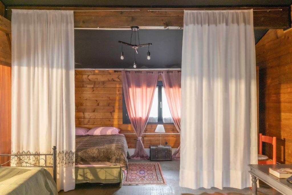 a bedroom with a bed and two windows with curtains at Casa Museo Colombo in San Giorgio