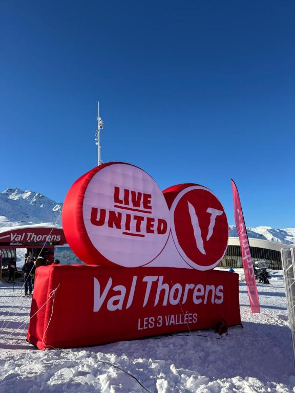 APT confortable centre station face aux pistes de Val Thorens في فال تورن: لافتة كُتب عليها "عِش مُتحدًا" و"فال ثورنس" في الثلج