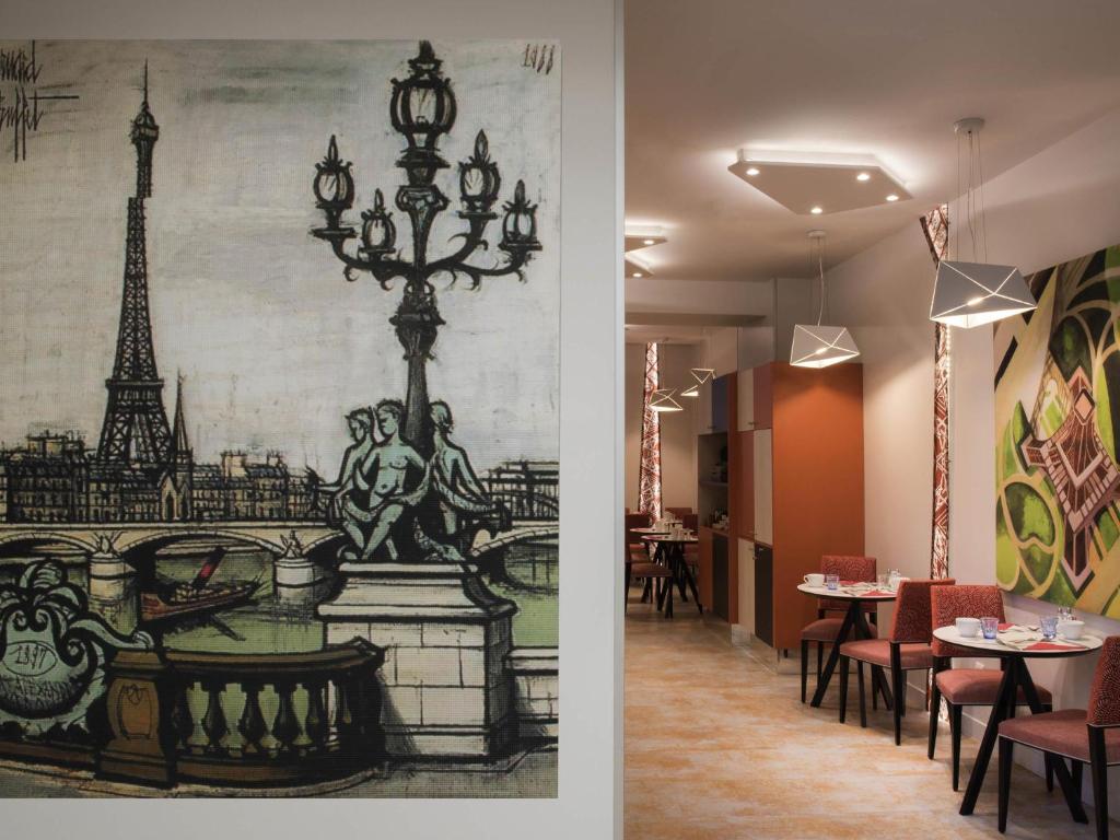 un comedor con un mural de la torre Eiffel en Mercure Paris Pont de Levallois Neuilly, en Levallois-Perret