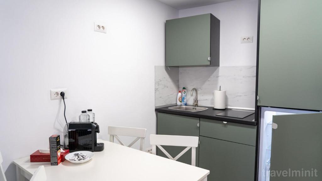 a kitchen with a white counter and a white table at Sea La Vie in Mangalia